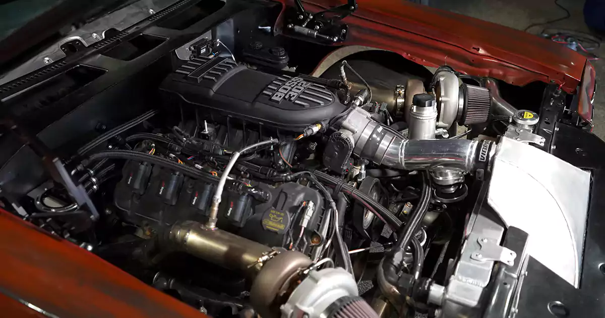 Twin-turbo Ford Coyote engine in a 1970 Chevelle, with two turbos, open air filters and polished intercooler piping.